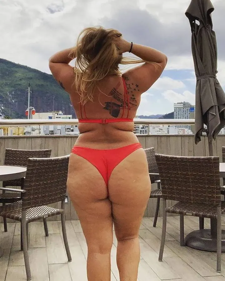 Femme blonde en maillot de bain rouge, de dos, sur une terrasse