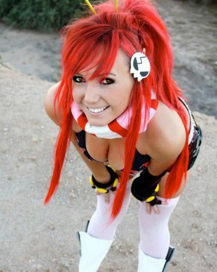 Jeune femme rousse en costume de cosplay, souriante en extérieur