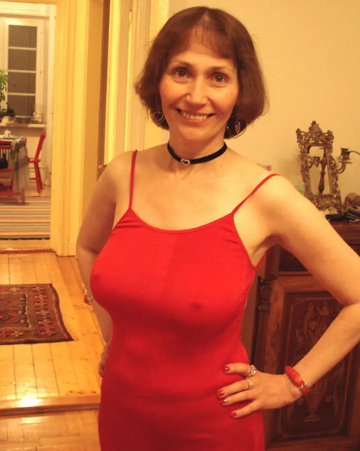 Femme en haut noir, cheveux bruns, souriant dans un salon