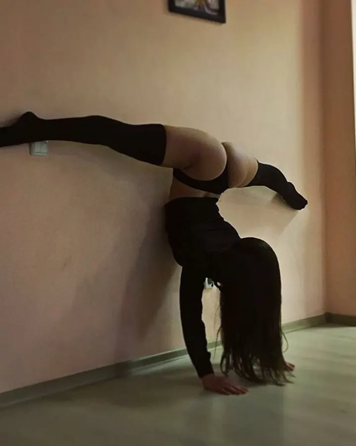 Noémie en position de yoga contre un mur rose
