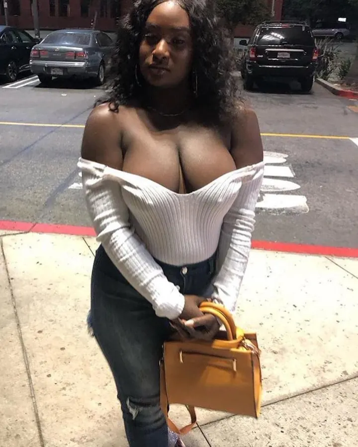 Femme noire en top blanc, sac jaune, regard vers l’appareil.