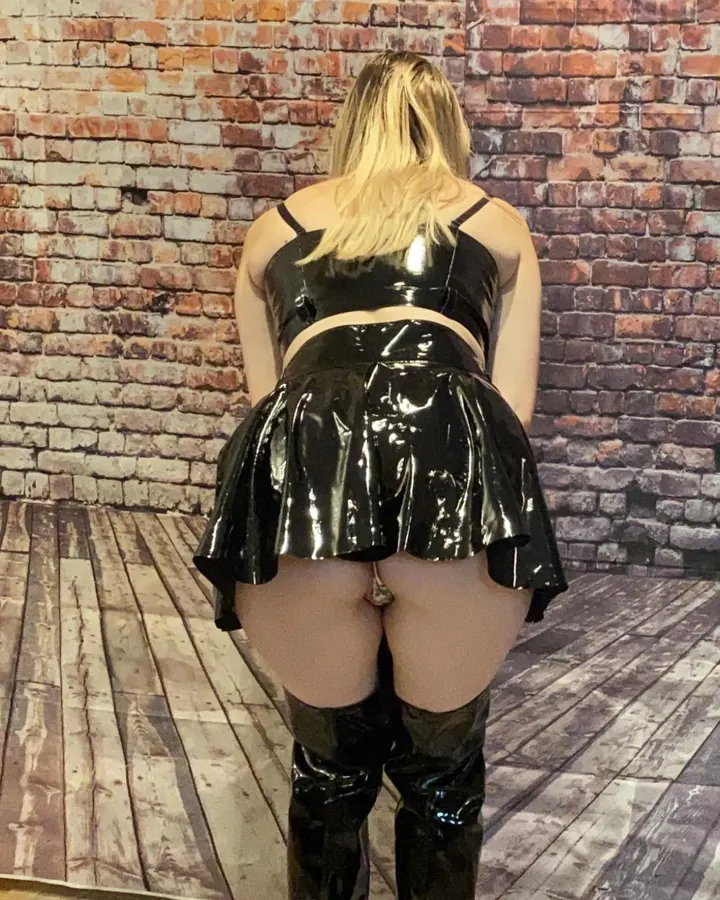 Femme en tenue de lingerie rose, prenant un selfie dans un miroir.
